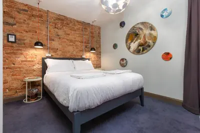 a bed in a room with a brick wall at ART B&B in Blackpool