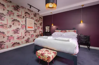 a bedroom with a large bed with purple walls at ART B&B in Blackpool