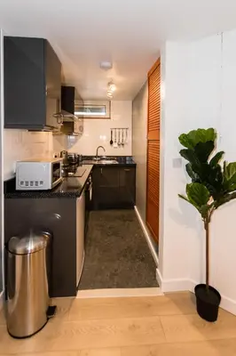 a kitchen with a black counter top and a plant at 1 Bedroom Newton Apartment l Free Parking l Wigan Royal Infirmary l Haigh Hall l Central Location in Wigan
