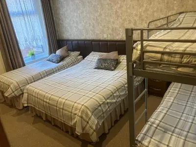 a bedroom with two beds and a bunk bed at Pearl Hotel in Blackpool