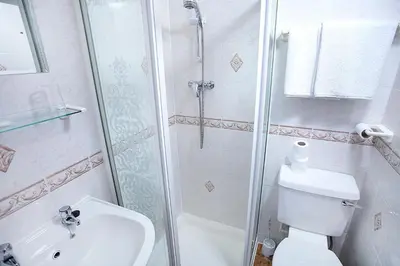 a bathroom with a shower and a toilet and a sink at Pearl Hotel in Blackpool