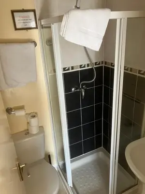 a bathroom with a shower and a toilet and a sink at Pearl Hotel in Blackpool