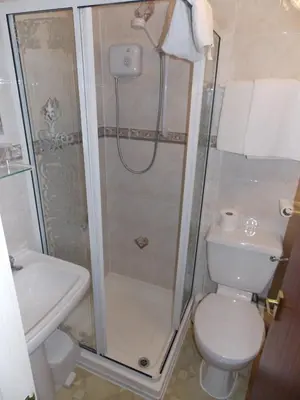 a bathroom with a shower and a toilet and a sink at Pearl Hotel in Blackpool
