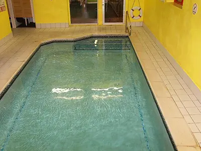 a swimming pool in a room with a tiled floor at The Woodfield Hotel , Indoor Heated swimming pool, Spacious lounge and Bar in Blackpool