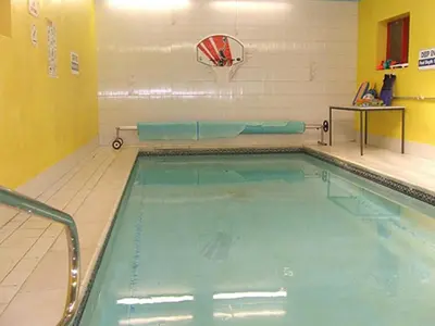 a swimming pool in a gym with a basketball hoop at The Woodfield Hotel , Indoor Heated swimming pool, Spacious lounge and Bar in Blackpool