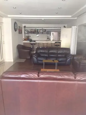 a living room with a leather couch and a bar at The Woodfield Hotel , Indoor Heated swimming pool, Spacious lounge and Bar in Blackpool