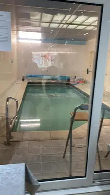 a swimming pool seen through a glass window at The Woodfield Hotel , Indoor Heated swimming pool, Spacious lounge and Bar in Blackpool