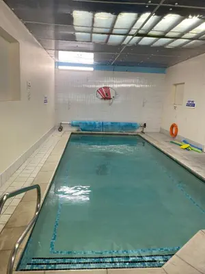 a large swimming pool in a gym at The Woodfield Hotel , Indoor Heated swimming pool, Spacious lounge and Bar in Blackpool