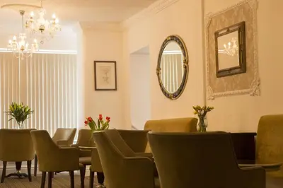 a room with a table and chairs and a mirror at The Royal Alexandra Hotel by Compass Hospitality in Blackpool