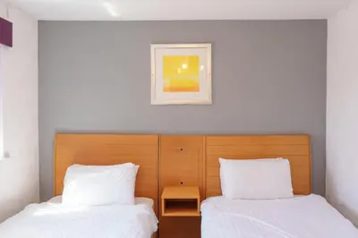 a bedroom with two beds and a picture on the wall at The Royal Alexandra Hotel by Compass Hospitality in Blackpool