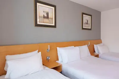 two beds in a hotel room with white pillows at The Royal Alexandra Hotel by Compass Hospitality in Blackpool