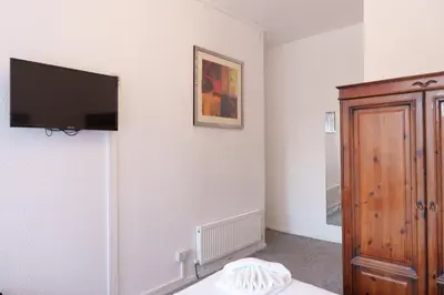 a bedroom with a flat screen tv on the wall at The Royal Alexandra Hotel by Compass Hospitality in Blackpool