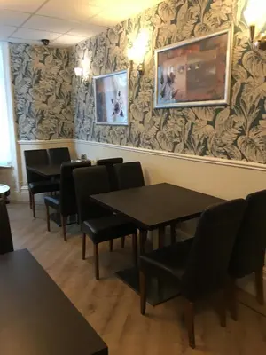 a dining room with tables and chairs and wallpaper at The Aspire in Blackpool