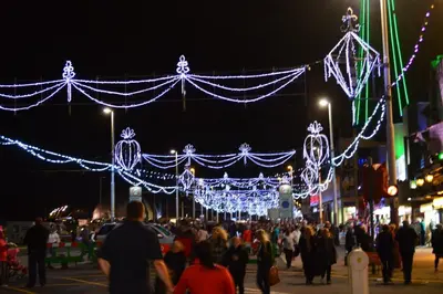 a crowd of people walking down a street with christmas lights at The Aspire in Blackpool