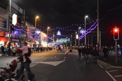 a group of people walking down a city street at night at The Aspire in Blackpool