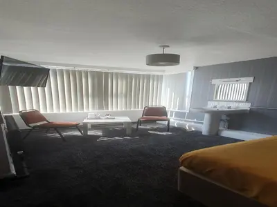 a room with two chairs and a bed and a table at South Beach Kings Promenade Hotel in Blackpool
