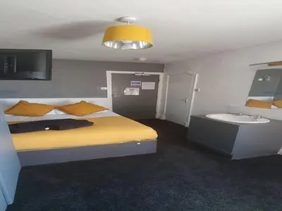 a bedroom with a bed and a sink and a bed and a lamp at South Beach Kings Promenade Hotel in Blackpool