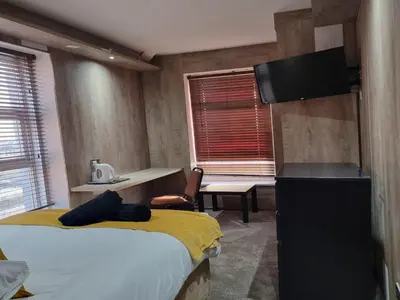 a room with two beds and a table and a desk at South Beach Kings Promenade Hotel in Blackpool