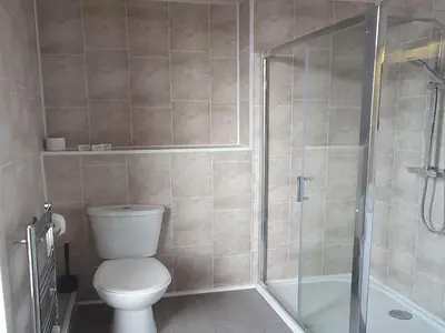 a bathroom with a toilet and a shower at South Beach Kings Promenade Hotel in Blackpool