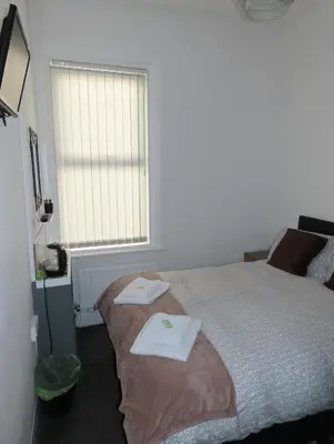a bedroom with a bed with two towels on it at Willin House Hotel in Blackpool