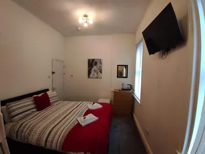 a small bedroom with a bed and a television at Willin House Hotel in Blackpool