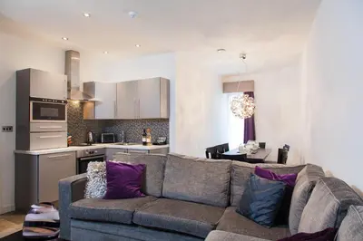 a living room with a couch and a kitchen at EPIC Apart Hotel - Seel Street in Liverpool