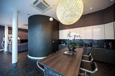 a kitchen with a wooden table and chairs and a chandelier at EPIC Apart Hotel - Seel Street in Liverpool