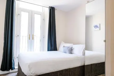 a bedroom with a large bed and a window at Liverpool City Centre - Spacious Duplex - 6 Bedrooms - Sleeps 14 People in Liverpool