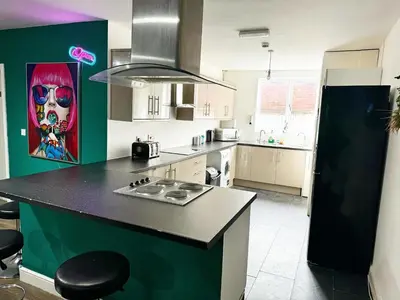 a kitchen with a black counter and a green wall at Liverpool City Centre - Spacious Duplex - 6 Bedrooms - Sleeps 14 People in Liverpool