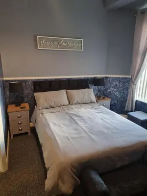 a bedroom with a large bed with a sign on the wall at Thornhill Blackpool in Blackpool
