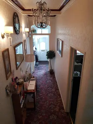 a room with a hallway with a chandelier and a room with a table at Thornhill Blackpool in Blackpool