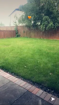 an orange frisbee in the air over a yard at semi-detach in Saint Helens