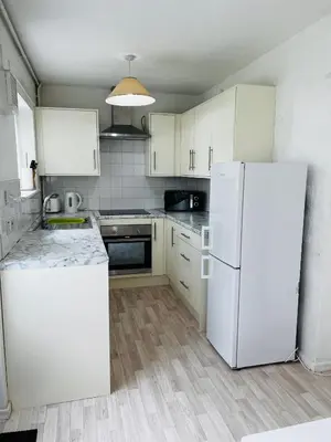 a kitchen with white cabinets and a white refrigerator at semi-detach in Saint Helens