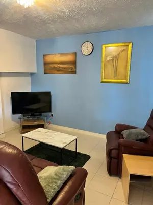 a living room with couches and a clock on the wall at semi-detach in Saint Helens