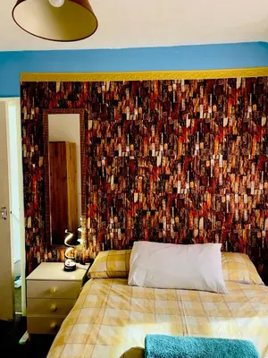 a bedroom with a large bed with a wall covered in photographs at semi-detach in Saint Helens