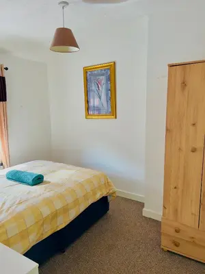 a bedroom with a bed and a wooden cabinet at semi-detach in Saint Helens