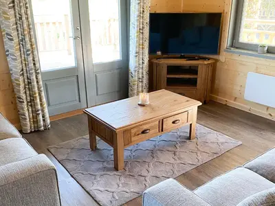 a living room with a coffee table and a tv at Cedar Lodge - Uk30008 in Lindal in Furness