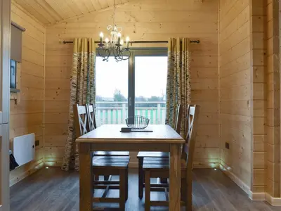 a dining room with a wooden table and chairs at Cedar Lodge - Uk30008 in Lindal in Furness