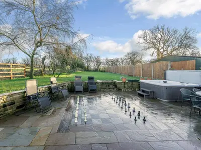 a patio with a bunch of chairs and a hot tub at Adamsons Barn in Inglewhite