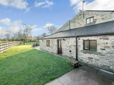 an old stone house with a grass yard at Adamsons Barn in Inglewhite