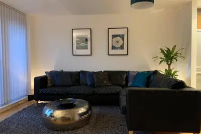 a living room with a black couch and a table at Duke Street - Liverpool city centre apartment in Liverpool