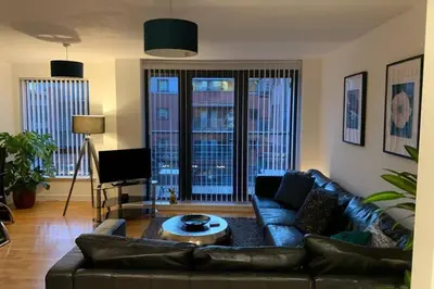 a living room with a leather couch and a table at Duke Street - Liverpool city centre apartment in Liverpool