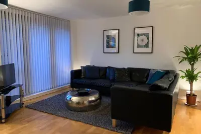 a living room with a black couch and a table at Duke Street - Liverpool city centre apartment in Liverpool