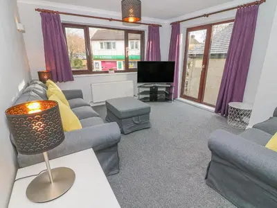 a living room with two couches and a tv at Rose Cottage in Grange Over Sands
