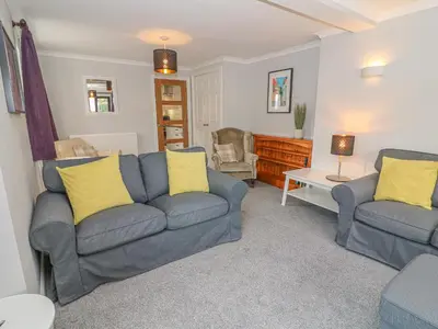 a living room with two couches and a table at Rose Cottage in Grange Over Sands
