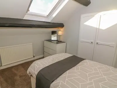 a bedroom with a bed and a skylight at Rose Cottage in Grange Over Sands