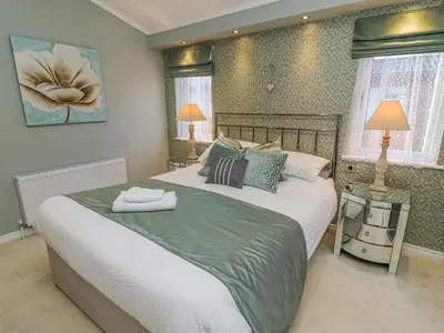 a bedroom with a large bed and two lamps at Shore Beats Work - Capenwray 10 in Carnforth
