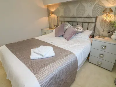a bedroom with a large bed with towels on it at Shore Beats Work - Capenwray 10 in Carnforth