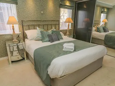 a bedroom with two beds and a large mirror at Shore Beats Work - Capenwray 10 in Carnforth