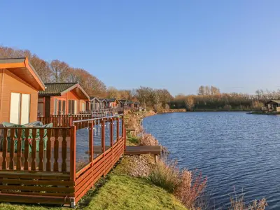 a row of houses next to a body of water at Shore Beats Work - Capenwray 10 in Carnforth